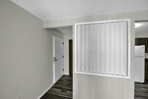 a white sliding door in a room with a hallway and a kitchen
